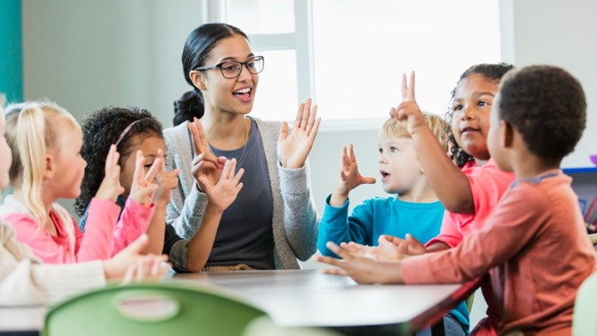 Leerkrachte helpt kinderen met dyscalculie rekenen